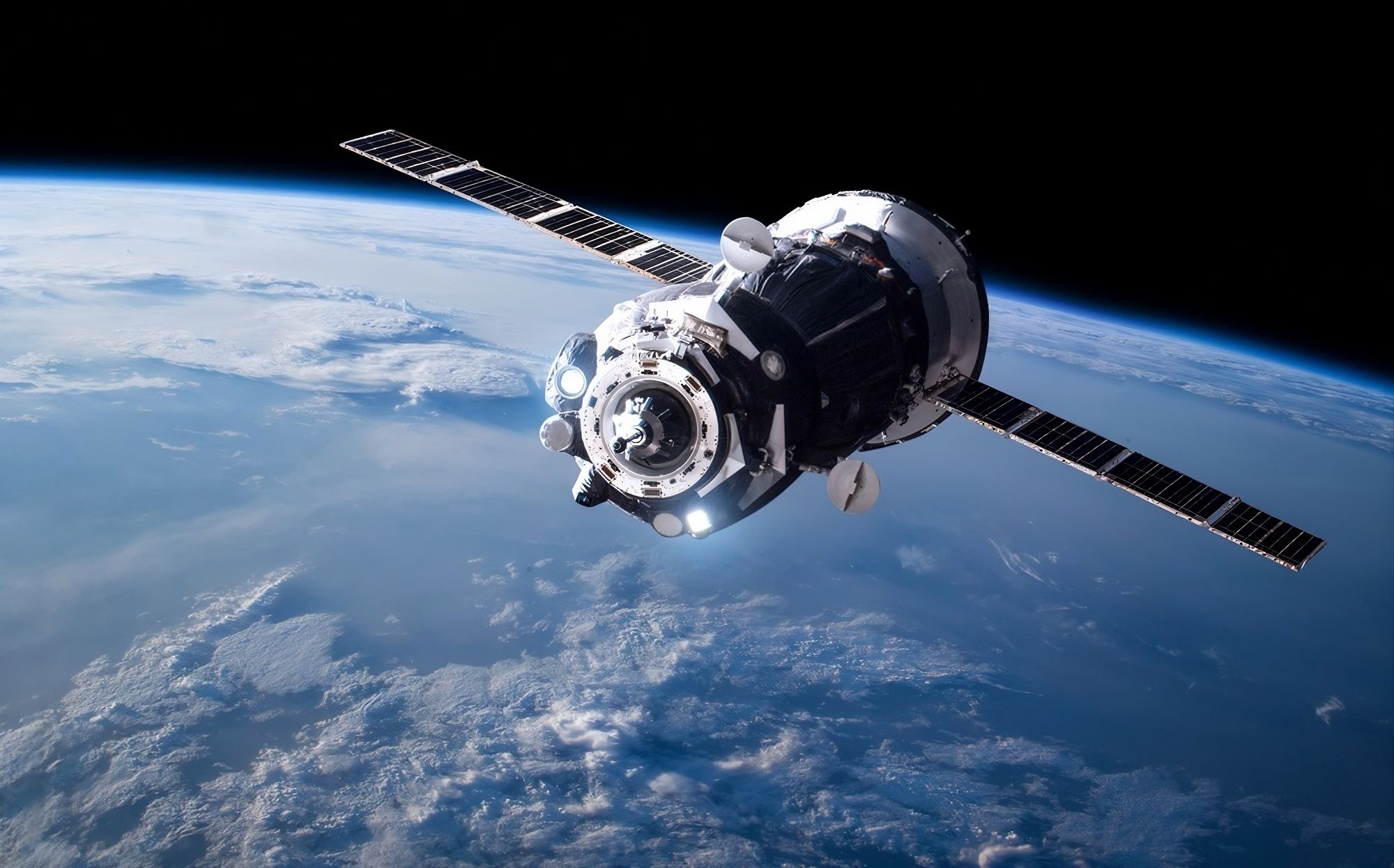 Vaisseau spatial en orbite au-dessus de la Terre, panneaux solaires déployés