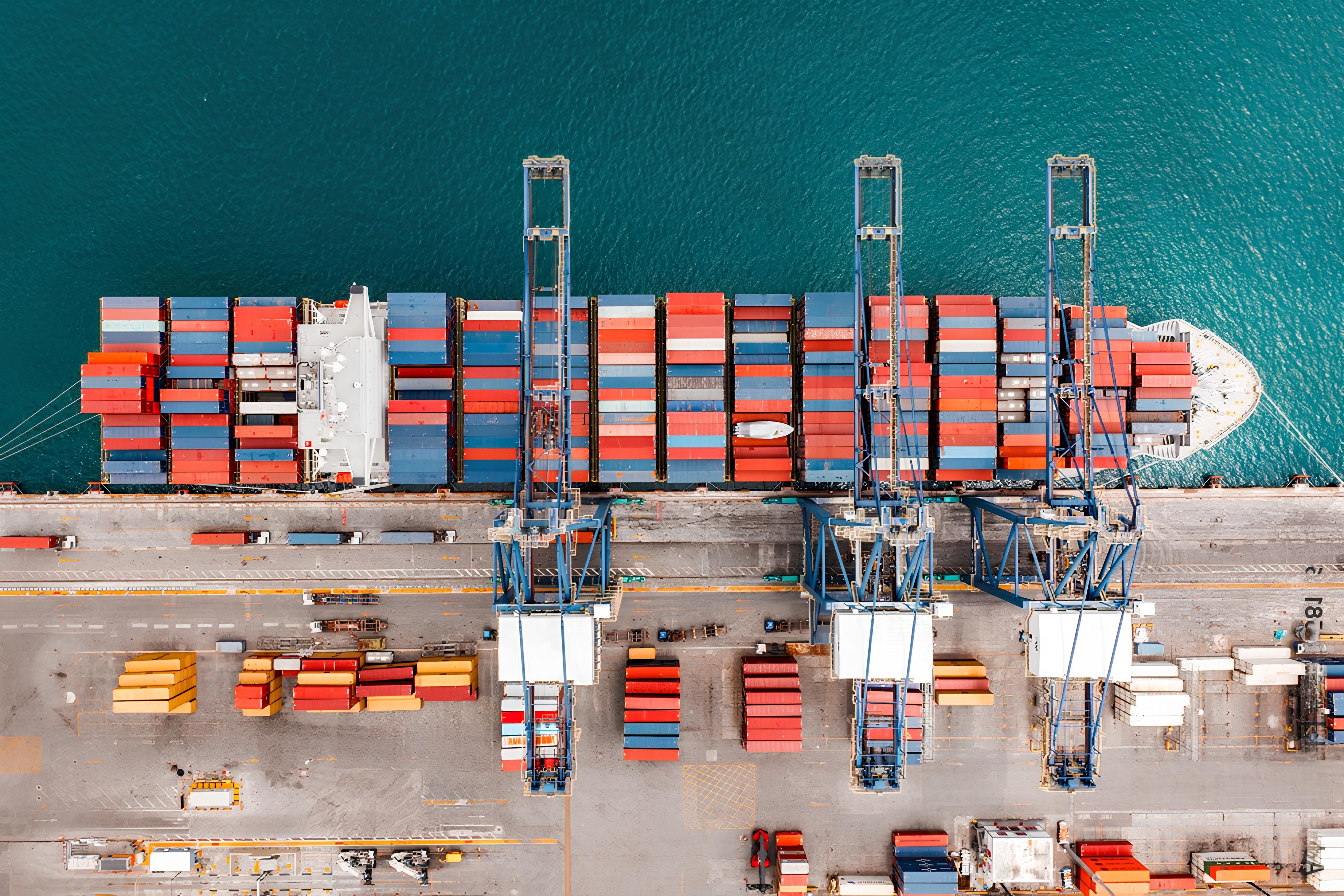Terminal à conteneurs vu du ciel : porte-conteneurs à quai et portiques de déchargement